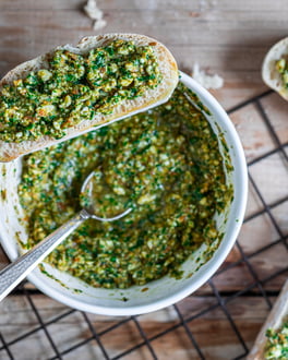 pesto alla trapanese in einer weißen Schüssel und auf drei Brotscheiben verteilt