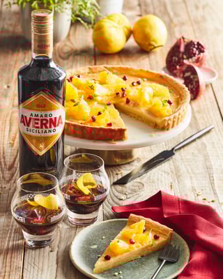 Crostata mit Orangen, daneben stehen eine Flasche und zwei Gläser Averna
