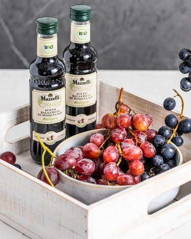 Rote und blaue Trauben in Kiste mit Bio-Balsamico
