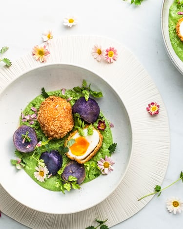 Zwei Schüsseln mit grüner Sauce, gebackenem Ei und Blüten