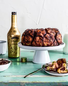 Schoko-Monkey Bread auf weißer Tortenplatte mit Baileys Chocolat Luxe.