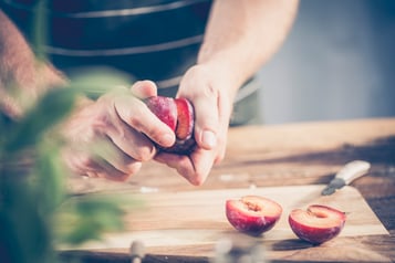 Geschnittene Pflaumenhälften werden getrennt.