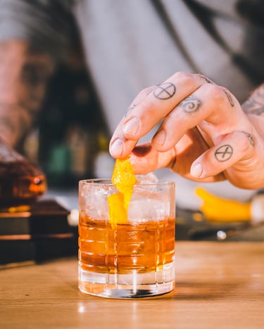Ein Shortdrink wird mit einer gedrehten Zeste garniert.