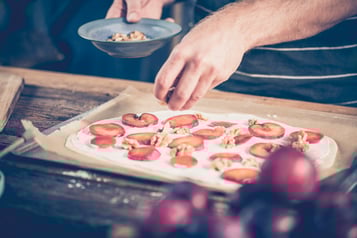 Der Flammkuchen wird belegt.