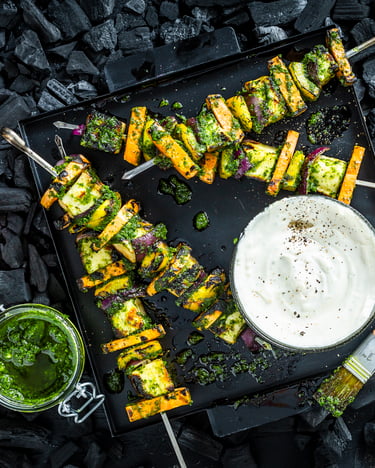 Das Wechselspiel aus Halloumi und Süßkartoffel ist aufgespießt und üppig mit Kräutermarinade bepinselt.