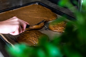 Der Lebkuchenteig wird auf einem Backblech glattgestrichen