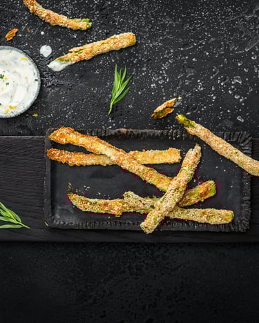 Spargel Pommes mit Zitronen-Dip und Estragon vor einem dunklen Hintergrund