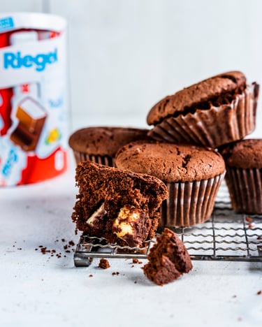Muffins auf Gitter mit Kinder Riegel im Hintergrund