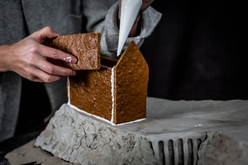 Teile des Lebkuchenhauses werden mit Zuckerguss festgeklebt