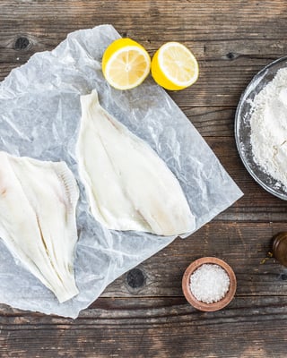 auf Holzuntergrund liegen 2 Stücke ungebratener Fisch