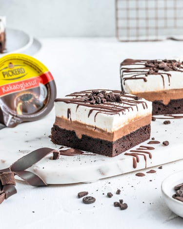 Drei Stücke Mississippi Mud Pie, Kakaoglasur und Mini-Schokokekse vor hellem Hintergrund