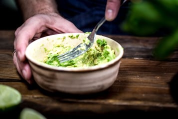 Avocado wird in einer Schüssel mit einer Gabel zerdrückt