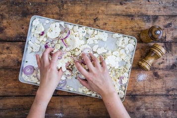 Zwiebeln und Blumenkohl-Stücke werden durchgemischt