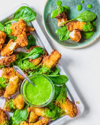 Fried Chicken mit Spinat-Buttermilch-Dip auf hellem Untergrund, von oben fotografiert.