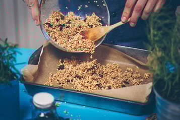 Salted Caramel Granola wird auf einem Backblech mit Backpapier verteilt