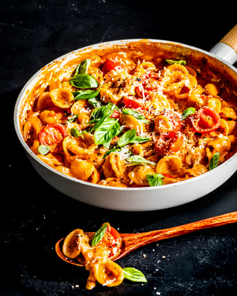 Orecchiette in einer Pfanne auf schwarzem Untergrund