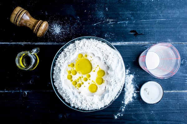 Zutaten für Pizzateig auf dunklem Holzuntergrund