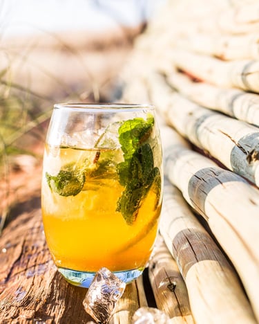 Ein Glas Eistee auf einem Stück Holz