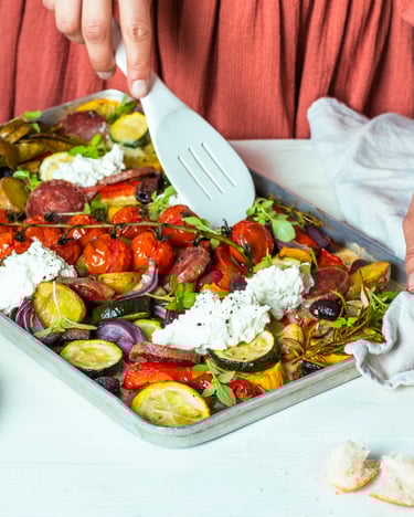 Ofengemüse auf Blech mit Ricotta, daneben liegt Weißbrot