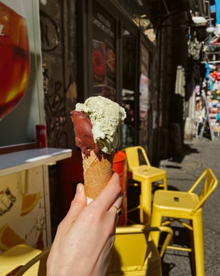 Eine Hand hält eine Waffel mit zwei Kugeln Eis