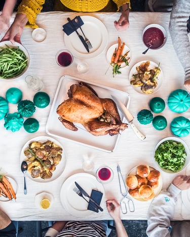 Eine Thanksgiving-Tafel mit Essen und vielen Personen am Tisch