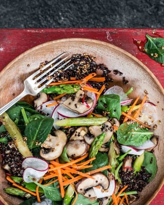 Quinoa-Salat mit Pilzen, Karotten, Spargel in einer Schüssel