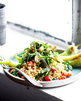 Hirse mit grüner Spitzpaprika und Rucola auf Fensterbrett fotografiert.