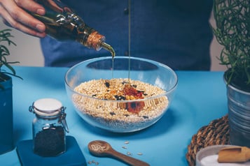 Honig wird in Granola-Mischung mit Quinoa gegeben.