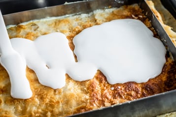 Der Guss wird auf die fertige Schnitte gegeben, die sich noch im Backrahmen befindet