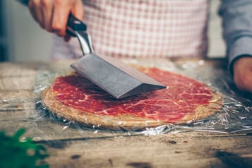 Das Carpaccio wird platt geklopft, darüber eine Frischhaltefolie