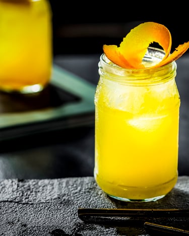 Auf schwarzem Untergrund steht ein Glas Bitterorangen-Tonic