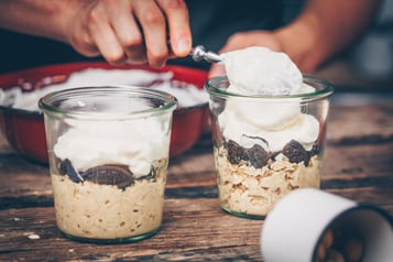 Cheesecake-Creme wird in die Gläser gegeben