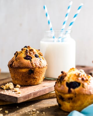 Muffins mit Heidelbeeren auf Holztisch mit Milchglas
