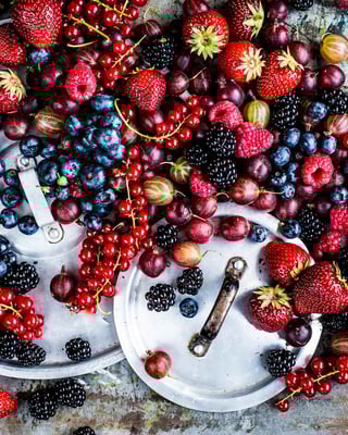 gemischte Beeren auf Topfdeckeln angerichtet von oben fotografiert
