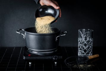 Brauner Zucker wird in einen Topf geschüttet, um Zuckersirup herzustellen