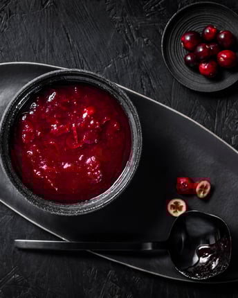 Eine Schale frische Cranberrysauce vor schwarzem Hintergrund