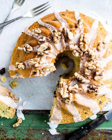 Angeschnittener polnischer Osterkuchen aus der Gugelhupfform mit Walnüssen auf eine grünen Holztisch