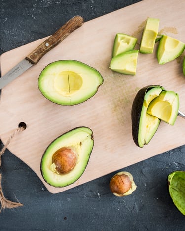 Eine Avocado aufgeschnitten auf einem Holzbrett