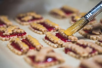 Die Plätzchen werden mithilfe eines Pinsels mit Eigelb bestrichen.