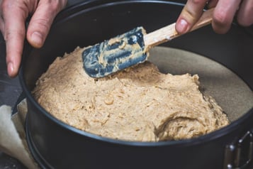 Der Teig wird in der Kuchenform glatt gestrichen.