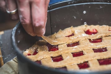 Teigstreifen werden wie ein Gitter auf die Marmelade gelegt.