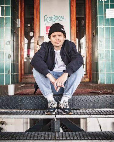Hannes sitzt auf den Treppen vor den FOODBOOM Studios