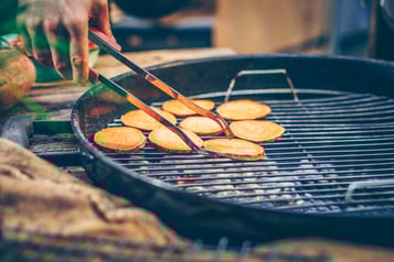 Süßkartoffelscheiben liegen auf einem Grillrost.
