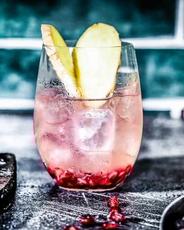Ein Glas Paloma Cocktail steht auf schwarzem Untergrund