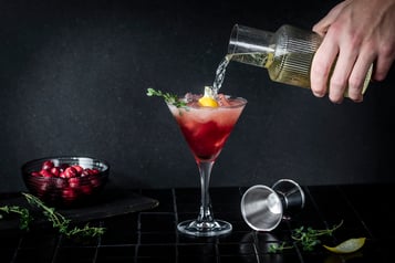 Ein roter Drink wird mit prickelndem Crémant aufgefüllt