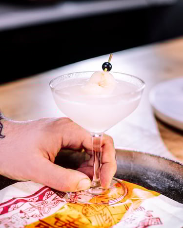Litschi Martini Cocktail auf einem Silbertablett mit asiatischer Serviette.