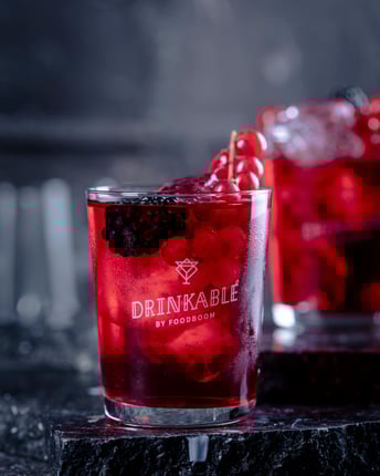 Zwei Gläser mit einem roten Drink und verschiedenen Beeren darin