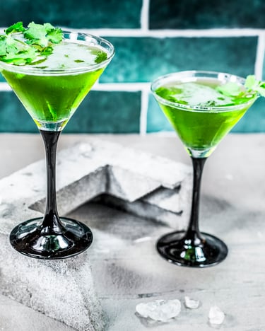2 Gläser mit dem grünen Drink stehen auf einem hellen Untergrund