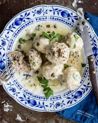 Königsberger Klopse auf einem weißen Teller mit blauem Muster