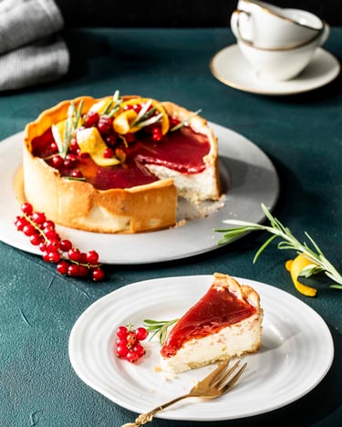 Glühwein-Cheesecake auf einem weißen Teller. Ein Stück ist bereits herausgeschnitten und liegt auf einem Teller.